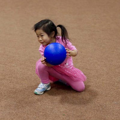 Young child holding blue dodgeball