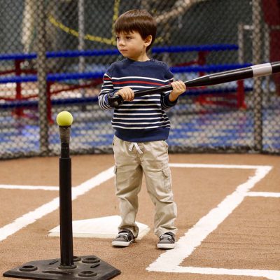 Boy swinging bat at tee-ball