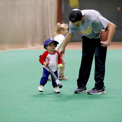 Instructor teaching child to hit